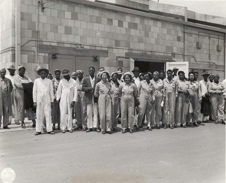 African-american women wearing coveralls standing in front of a building