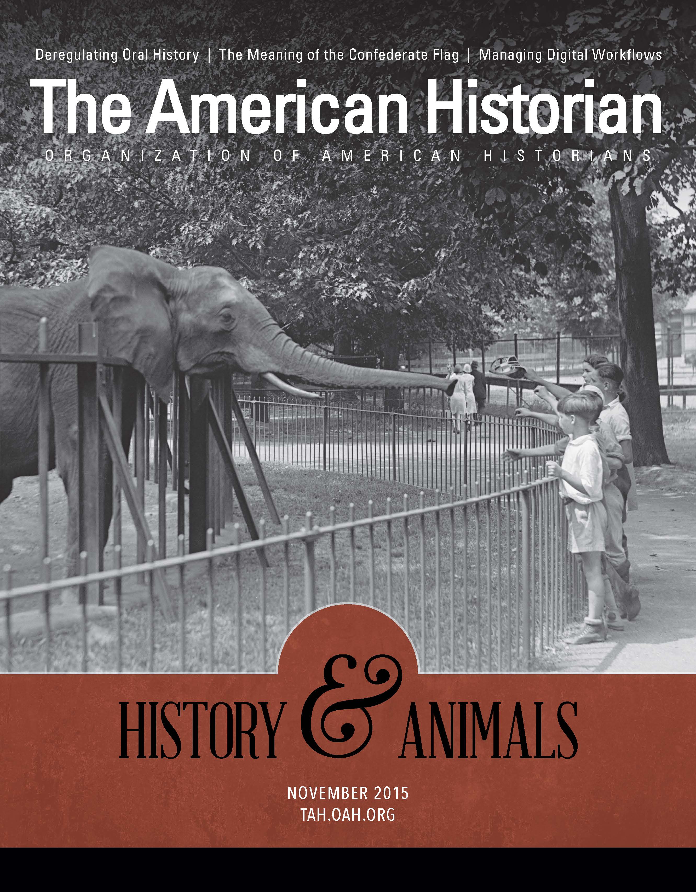 Children feed an elephant at a zoo in the photograph used for this issue's cover, and title of 