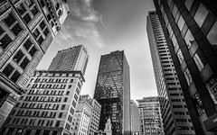 Several buildings of various heights from the perspective of the ground with open sky above the buildings